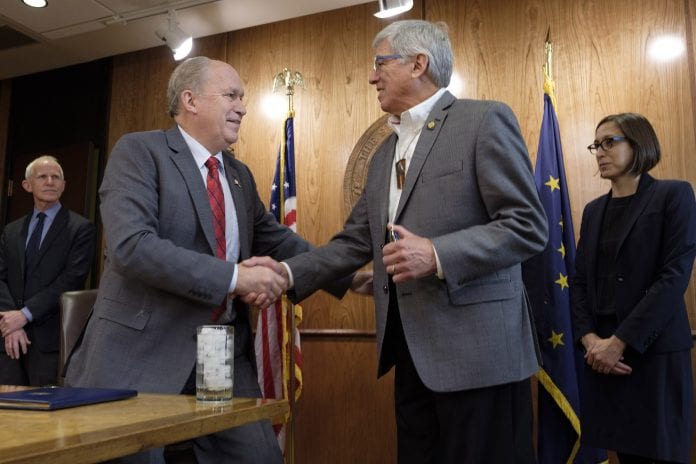 Governor Bill Walker shakes hands with Lieutenant Governor Byron Mallott after signing an Administrative Order on Climate Change, at the State Capitol in Juneau, Alaska, October 31, 2017.