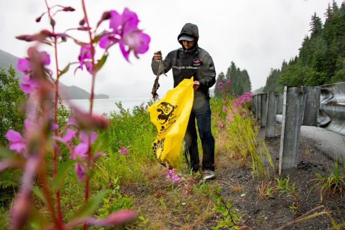 Volunteer Jonah Reutov cleans up garbage near the shore of Eyak Lake. The Saturday, July 27, 2019, cleanup organized by the Copper River Watershed Project and the Forest Service removed 12 cubic yards of waste from the area. Photo by Zachary Snowdon Smith/The Cordova Times