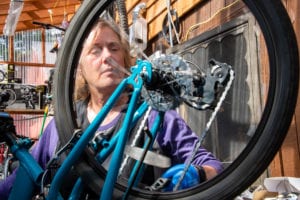 Natasha Casciano tests the rotation of a bicycle’s wheel. Casciano now offers repairs to bicycles from other retailers at Cordova Gear, seen here on Friday, Aug. 16, 2019. Photo by Zachary Snowdon Smith/The Cordova Times