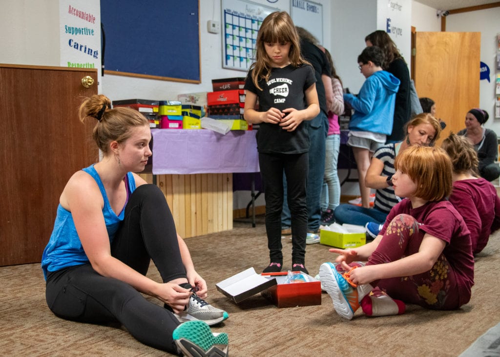 From left: Cordova Family Resource Center intern Jessica Kate Wray helps Grace Higgins and Evie Mills find properly fitting running shoes. The first meeting of the CFRC’s Girls on the Run program took place on Tuesday, Aug. 20, 2019. Photo by Zachary Snowdon Smith/The Cordova Times