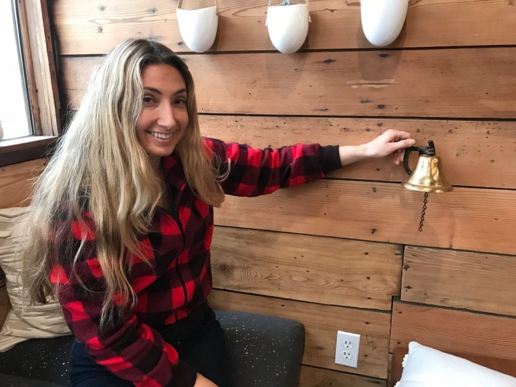 At the recently opened Kayak Cafe, Jane Spencer displays the highly prized CoHo Bar Bell that she won in bidding for artifacts from the famous old building. Photo by Dick Shellhorn/for The Cordova Times
