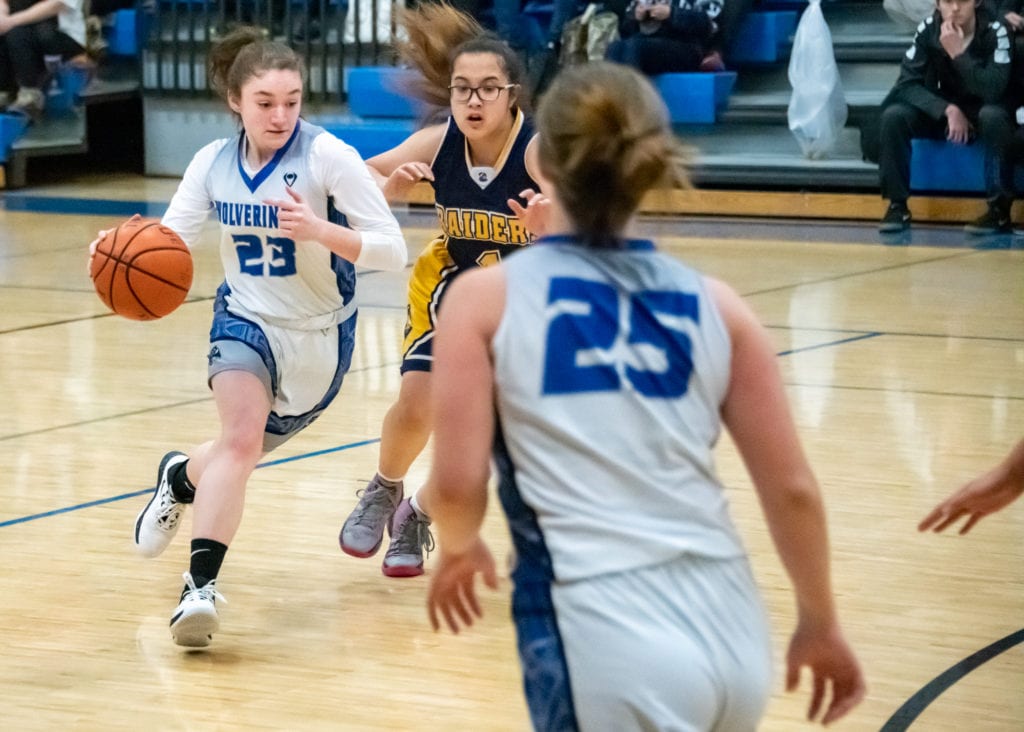 In first round action of the 38th Cordova Tipoff on Jan. 16, Lady Wolverine Inga Arvidson (23) drives past Vy Hyunh (1) of Unalaska. Photo by Zachary Snowdon Smith/The Cordova Times