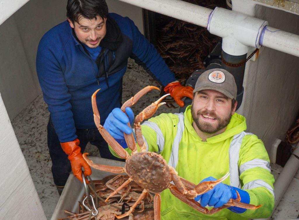 Johnathan Smallwood and Galen Meyer unload live tanner crab from the F/V Lucid Dream for dock sales in Cordova on Friday, Jan. 26, 2024. Photo by Kinsey Brown 